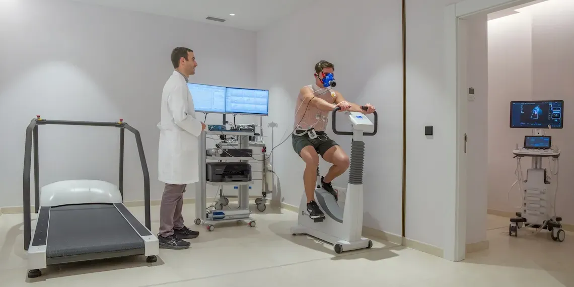 cardologie afdeling met man op een fietsmachine met sensoren op zijn lichaam en een zuurstofmasker op