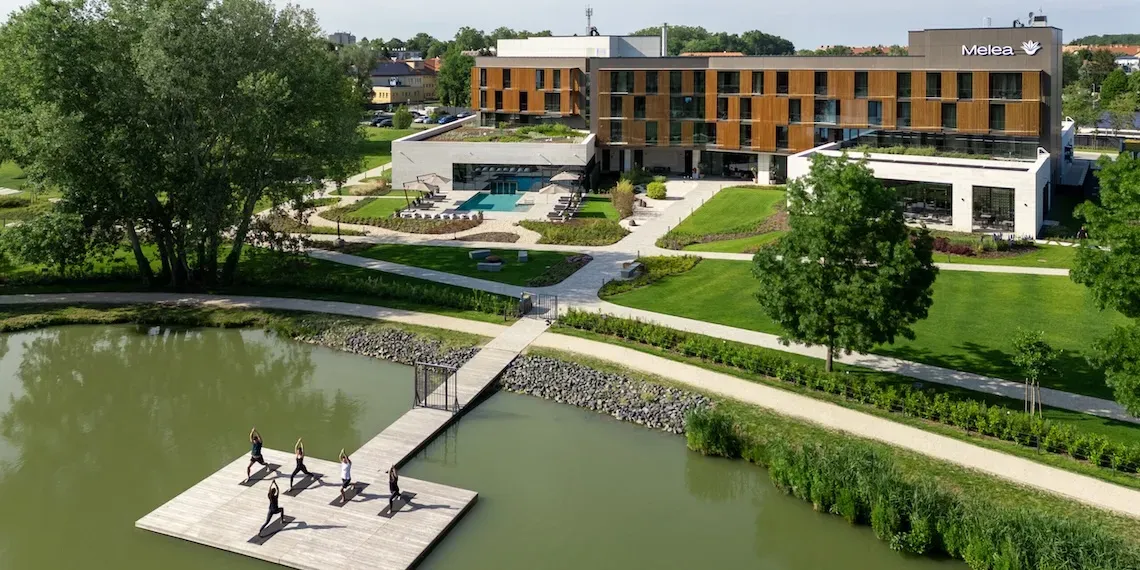 hotel met groep die yoga doet op het meer