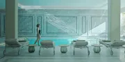 vrouw in een witte spa ruimte die loopt bij een zwembad en ligbedden